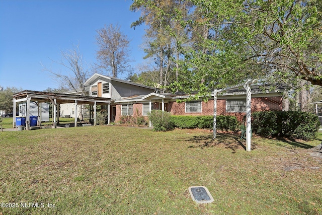 view of front facade with brick siding and a front lawn