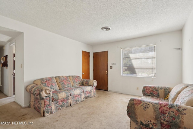 living area with visible vents, carpet, and a textured ceiling