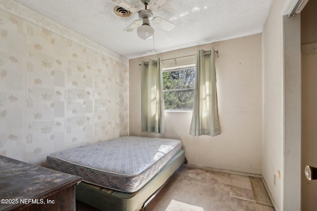 bedroom with visible vents, a textured ceiling, wallpapered walls, and ceiling fan