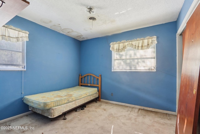 carpeted bedroom with baseboards, visible vents, a closet, and a textured ceiling