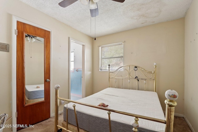 carpeted bedroom featuring ceiling fan, baseboards, and a textured ceiling