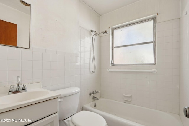 full bathroom with vanity, tile walls, washtub / shower combination, and toilet