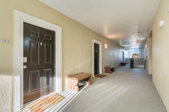 corridor with finished concrete flooring and a textured wall