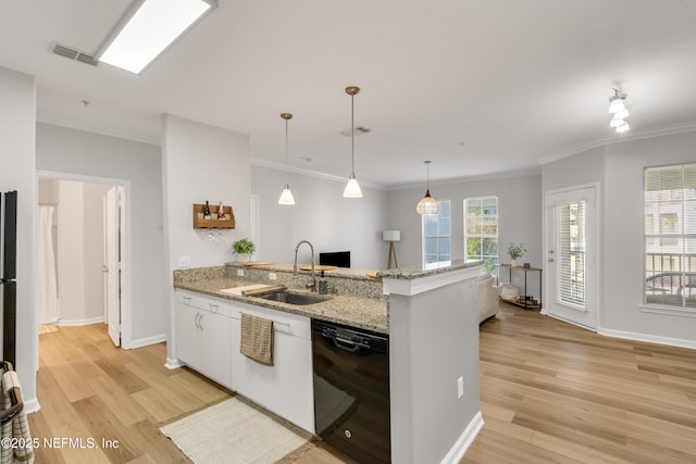 kitchen featuring black dishwasher, light wood-style floors, visible vents, and a sink