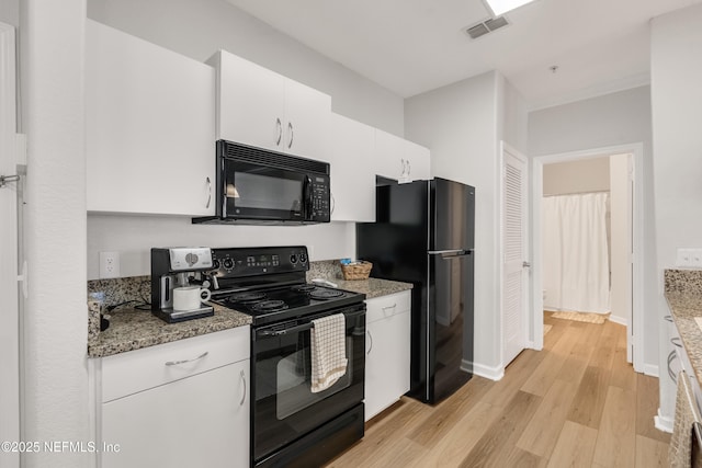 kitchen featuring light stone counters, visible vents, light wood finished floors, black appliances, and white cabinetry