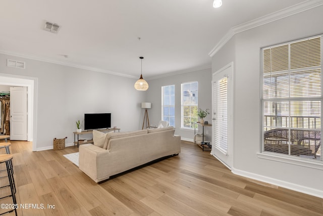 living room featuring visible vents, light wood-style flooring, crown molding, and baseboards