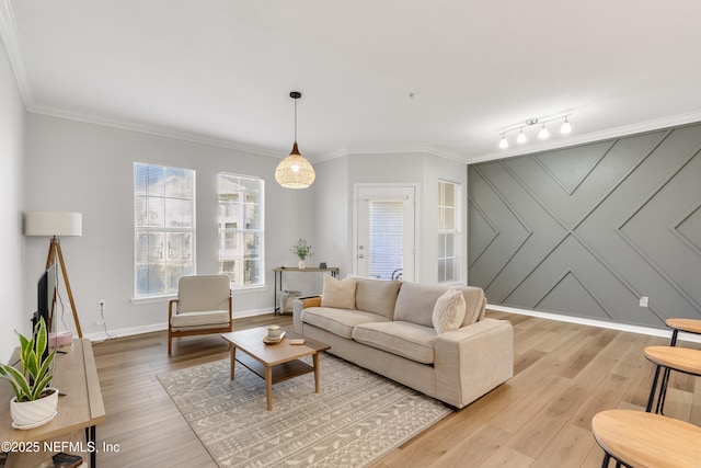 living room featuring light wood-style floors, baseboards, and ornamental molding