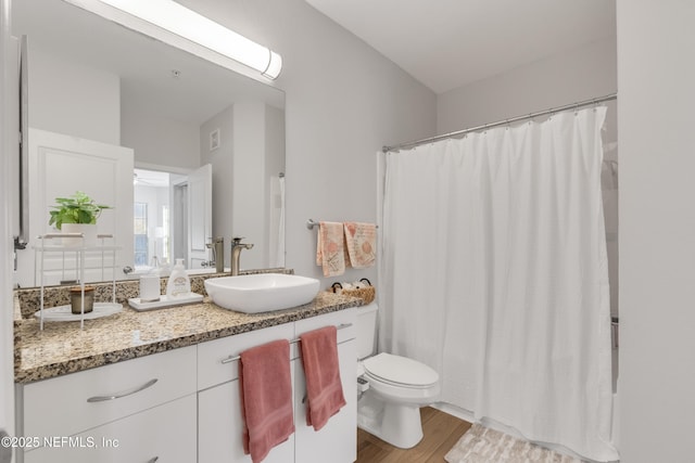 full bath featuring curtained shower, toilet, vanity, and wood finished floors