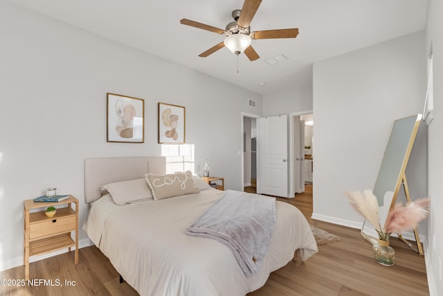 bedroom featuring a ceiling fan, visible vents, wood finished floors, and baseboards