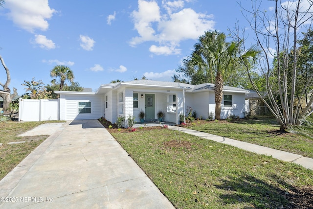 ranch-style house featuring a front yard, a porch, fence, and driveway