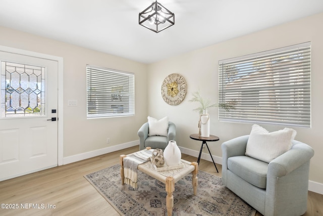 sitting room with baseboards and light wood-style floors