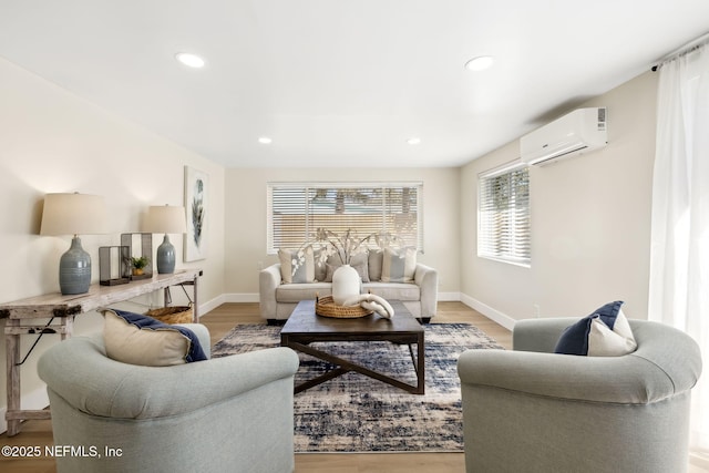 living area with recessed lighting, light wood-style flooring, a wall mounted AC, and baseboards