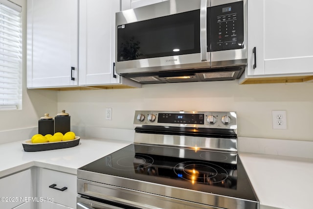 kitchen with appliances with stainless steel finishes, white cabinets, and light countertops