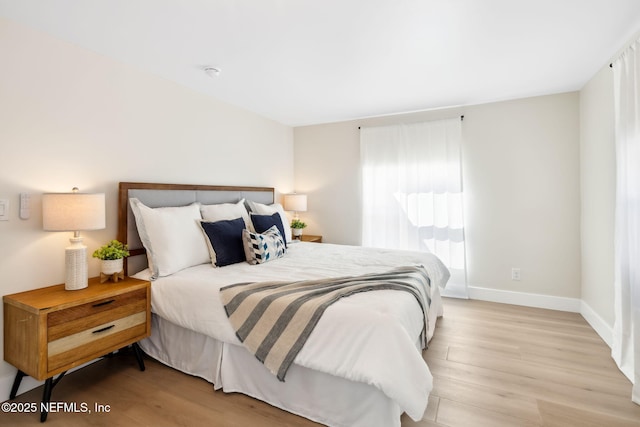 bedroom with baseboards and light wood-style flooring