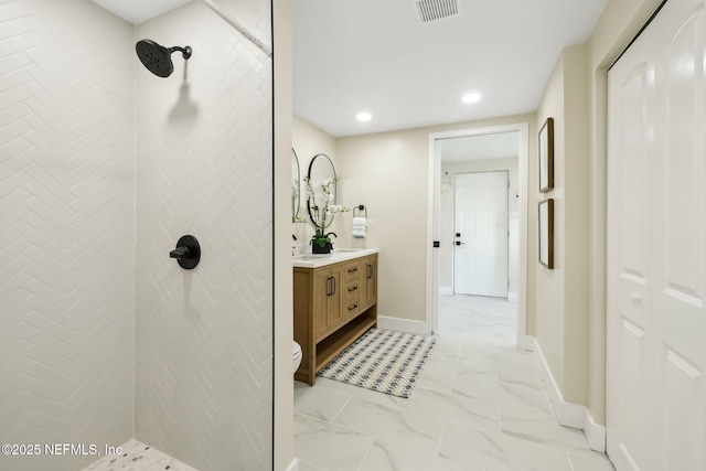 bathroom with visible vents, baseboards, a tile shower, marble finish floor, and vanity