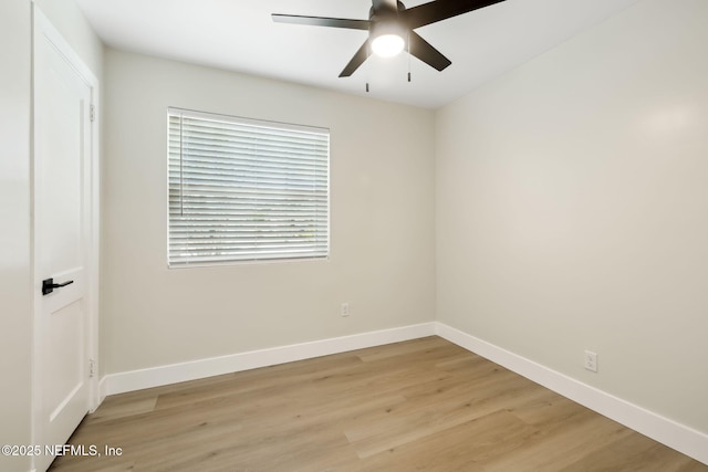 spare room featuring light wood finished floors, ceiling fan, and baseboards