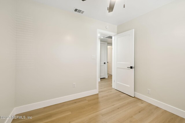 empty room with a ceiling fan, baseboards, visible vents, and light wood finished floors