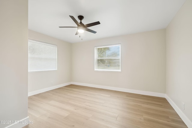 empty room featuring baseboards, light wood-style floors, and ceiling fan