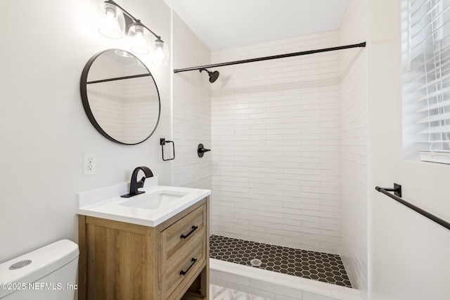 full bath featuring toilet, a stall shower, and vanity