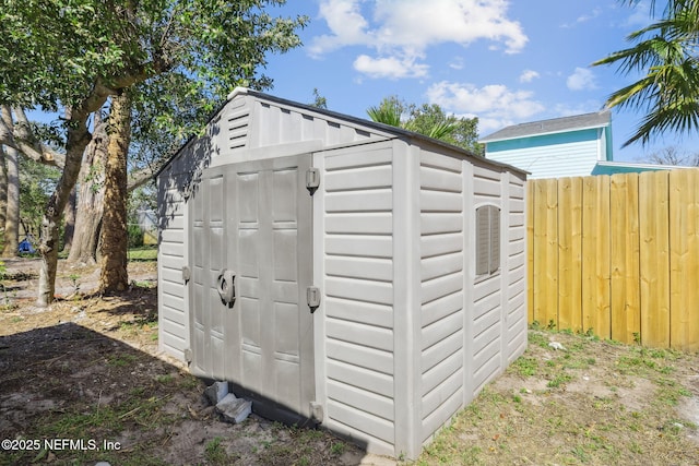 view of shed featuring fence