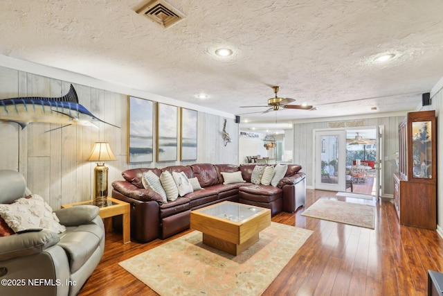 living area with hardwood / wood-style flooring, visible vents, and a textured ceiling