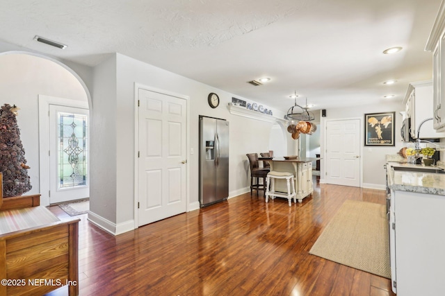 kitchen featuring visible vents, white cabinets, appliances with stainless steel finishes, and wood-type flooring