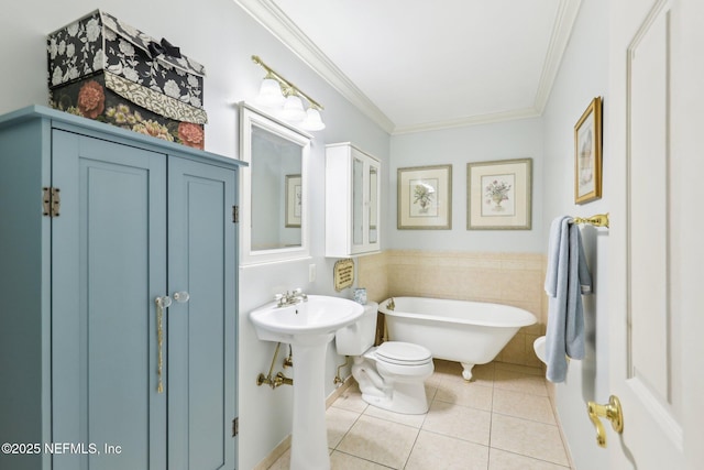 bathroom with tile patterned floors, a freestanding bath, crown molding, and toilet