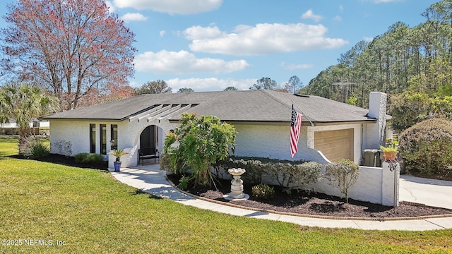 ranch-style home featuring a garage, driveway, a front yard, and a shingled roof