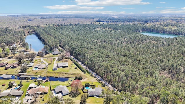 aerial view featuring a forest view and a water view