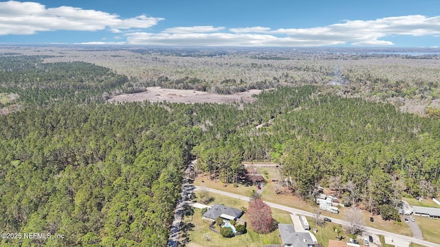 birds eye view of property featuring a view of trees