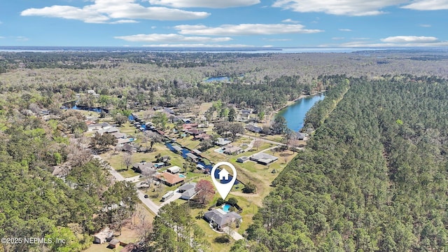 birds eye view of property featuring a forest view and a water view