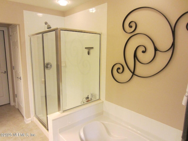 full bathroom with tile patterned floors, a garden tub, and a stall shower