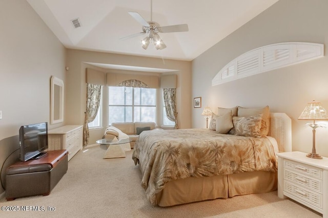 carpeted bedroom with visible vents, a ceiling fan, and vaulted ceiling