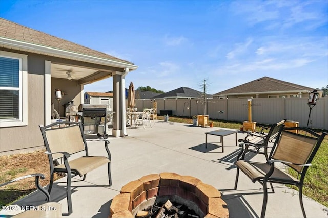 view of patio / terrace featuring a fire pit, ceiling fan, fence, outdoor dining area, and area for grilling