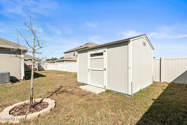 view of shed with central AC unit and a fenced backyard