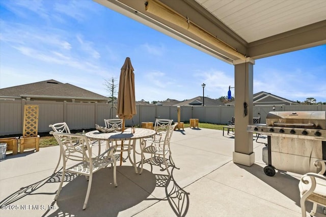 view of patio with outdoor dining space, a grill, and a fenced backyard