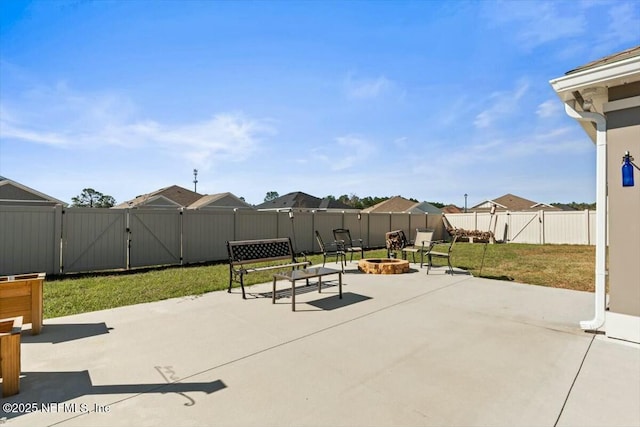 view of patio / terrace with a fire pit, a fenced backyard, and a gate