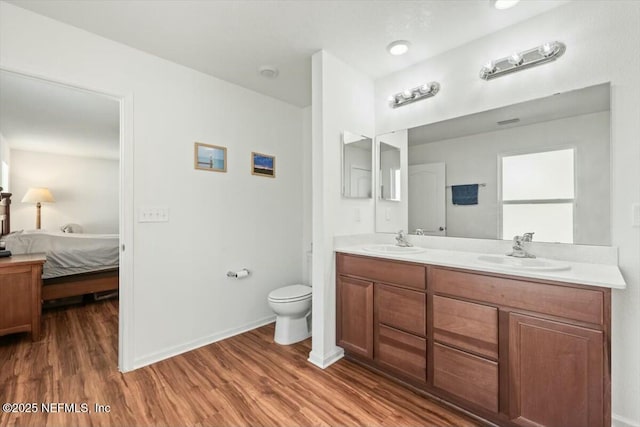 full bathroom featuring a sink, connected bathroom, toilet, and wood finished floors