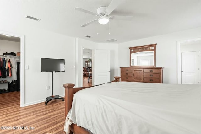 bedroom featuring a spacious closet, visible vents, a closet, and light wood-type flooring