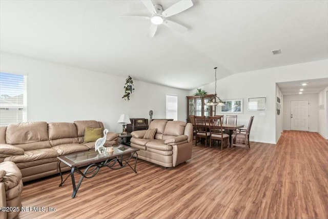 living area with lofted ceiling, light wood-type flooring, and ceiling fan