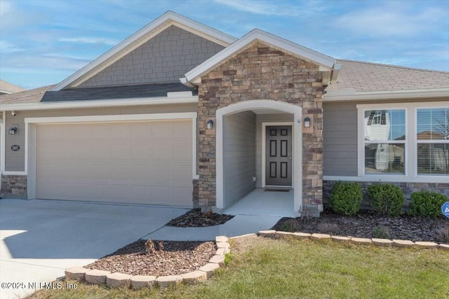 craftsman inspired home featuring stone siding, concrete driveway, a garage, and a shingled roof