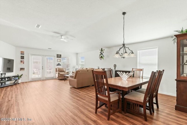 dining space featuring visible vents, baseboards, ceiling fan, french doors, and wood finished floors