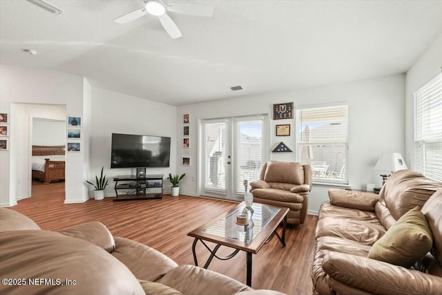 living area with a ceiling fan, wood finished floors, visible vents, lofted ceiling, and french doors