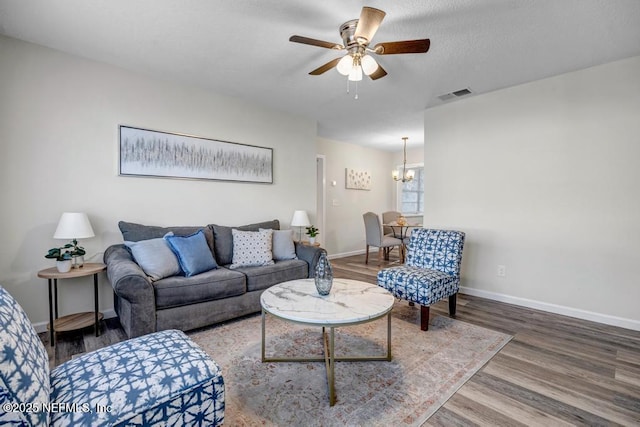 living room featuring visible vents, baseboards, and wood finished floors