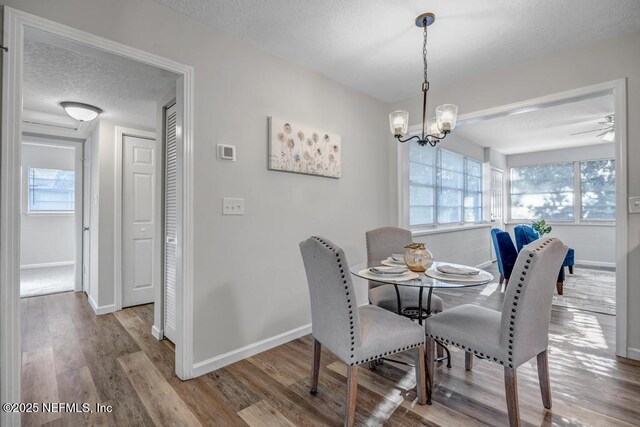 dining space with a textured ceiling, a healthy amount of sunlight, and wood finished floors