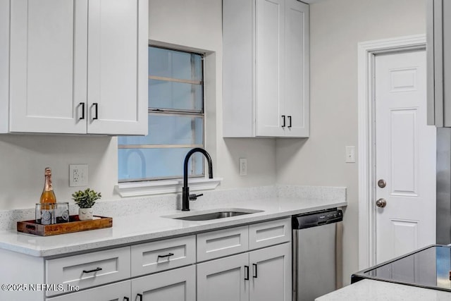 kitchen featuring a sink, light stone countertops, dishwasher, and white cabinets