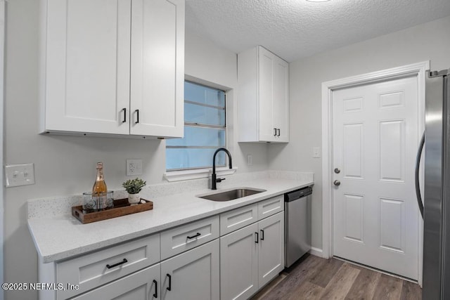 kitchen featuring white cabinetry, dark wood-style floors, appliances with stainless steel finishes, and a sink