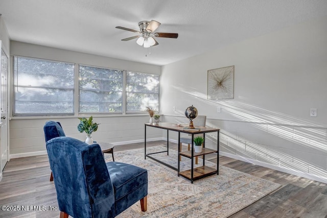 office with baseboards, a textured ceiling, a ceiling fan, and wood finished floors