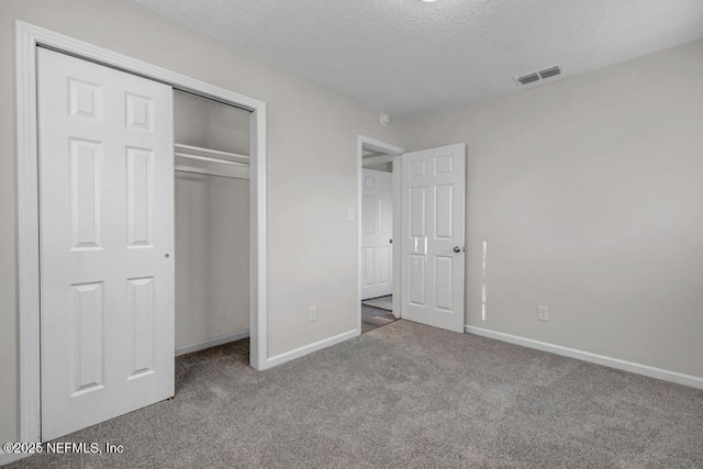 unfurnished bedroom with visible vents, baseboards, carpet, and a textured ceiling