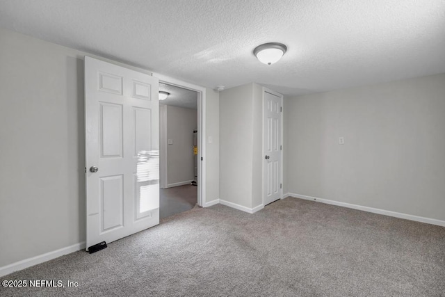 empty room featuring baseboards, carpet, and a textured ceiling